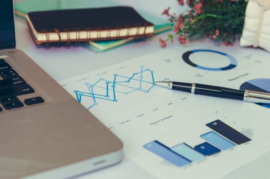 laptop with financial charts and graphs.